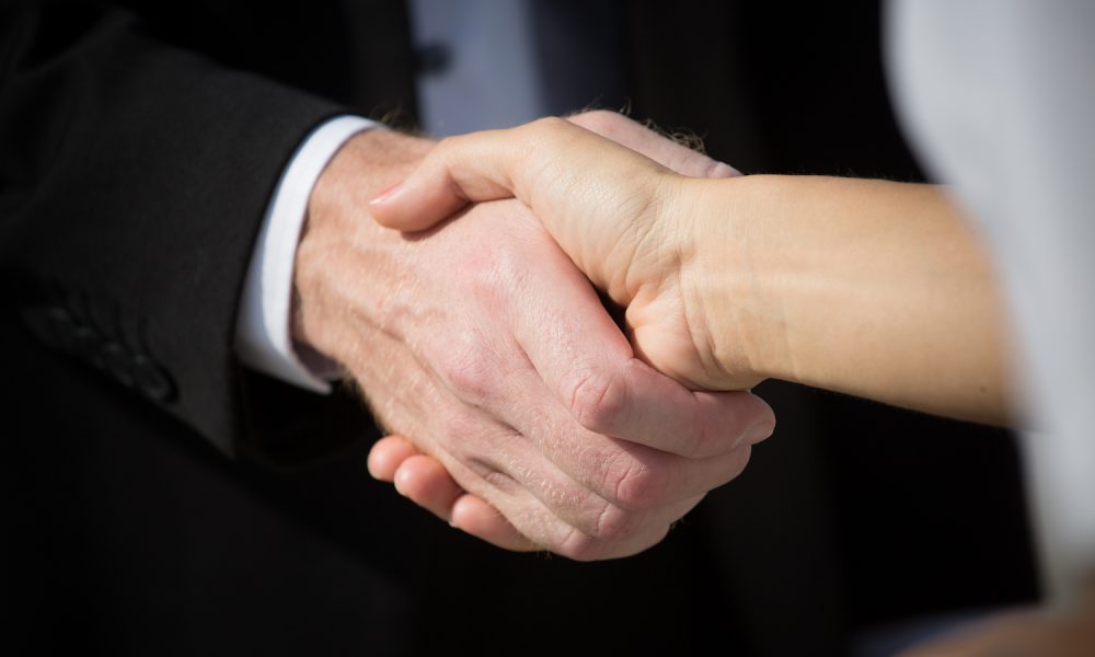 Business handshake and business people. Business handshake for closing the deal after singing the lucrative contract between companies.