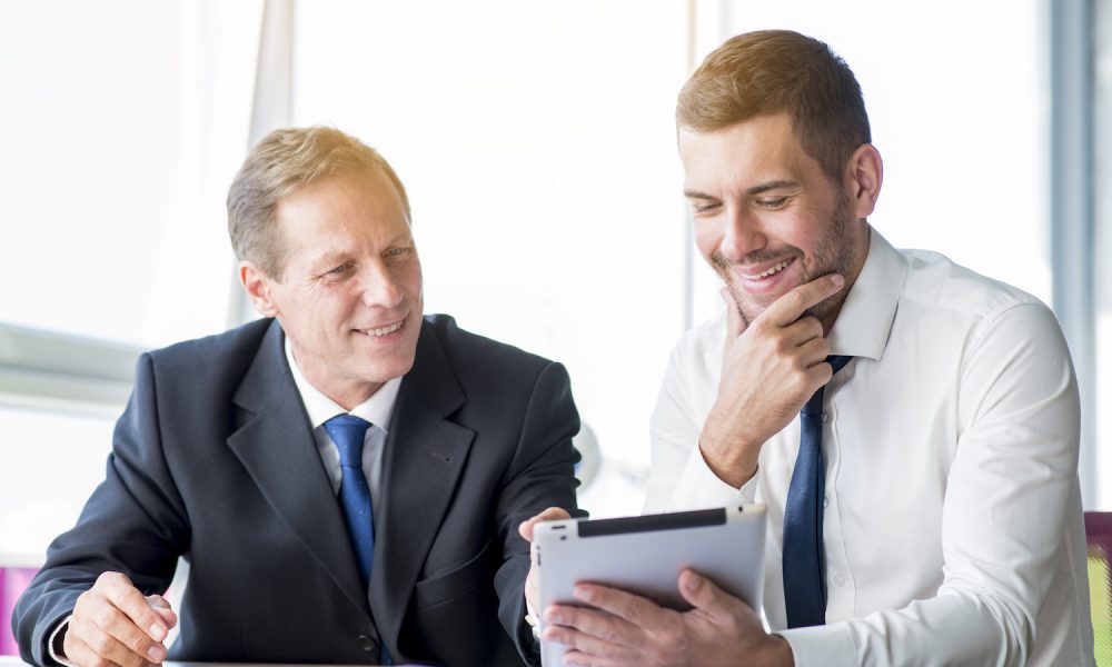 two-businessman-discussing-using-digital-tablet